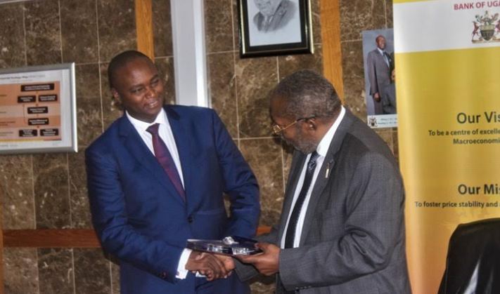 Patrick Mweheire, Chief Executive of Stanbic bank receives award of recognition for the best performing commercial bank trading in the Government securities from Governor Bank of Uganda, Emmanuel Mutebile.