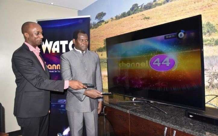 Charles Hamya (L) General Manager MultiChoice Uganda and Pastor Robert Kayanja tune in to Channel 44 on DStv during the launch ceremony