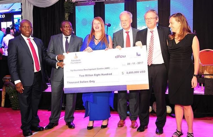 dfcu Bank board members with Agribusiness Development Centre and Rabobank Foundation executives show off the $2.8 million cheque for the ADC.