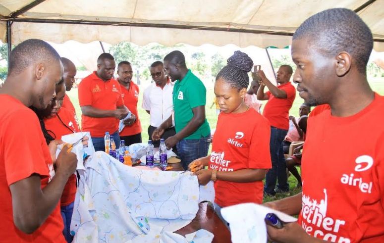 Airtel Uganda and HindsFeet staff members make reusable sanitary towels which were given to young women during the health camp.
