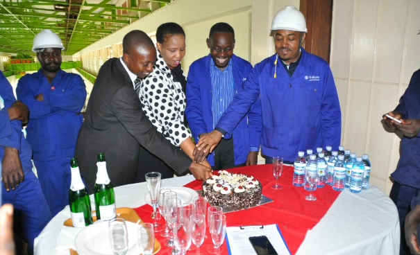 Eskom Uganda Managing Director Thozama Gangi (Middle) flanked by Finance Director Stephen Byaruhanga (In black suit), Ag.Technical Director Daniel Oluga (2 nd right) and Mr. Mohammed Mahsen former Technical Director cut a cake at the plant in celebration of the success with Unit 3